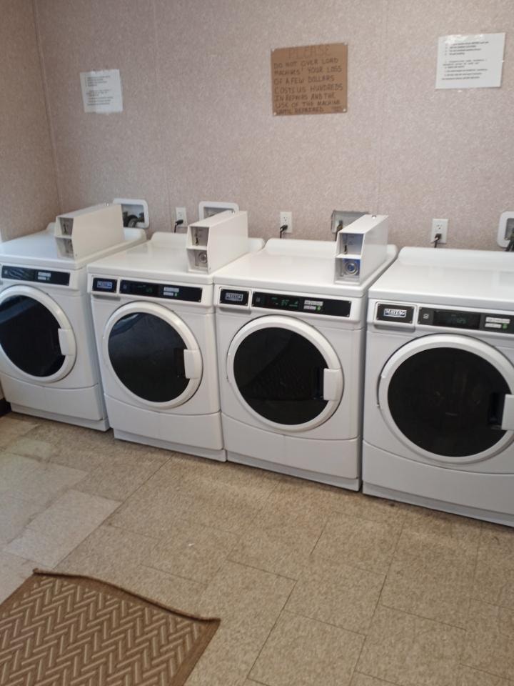 Coin-operated washer and dryer machines in the on-site laundry room