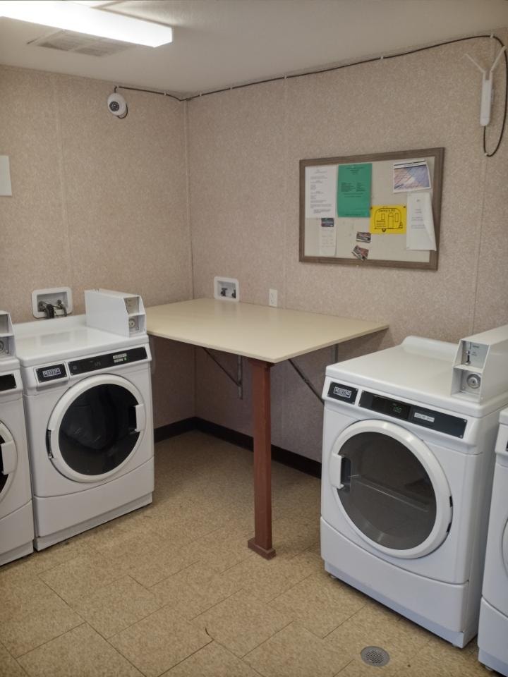 On-site laundry room with washers, dryers, and folding table at Double Time RV Park